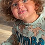 baby, cartoon, child, close_up, clothing, curly_hair, cute, expression, face, fun, indoor, natural_light, person, playful, portrait, shirt, simba, smiling, toddler, young_child