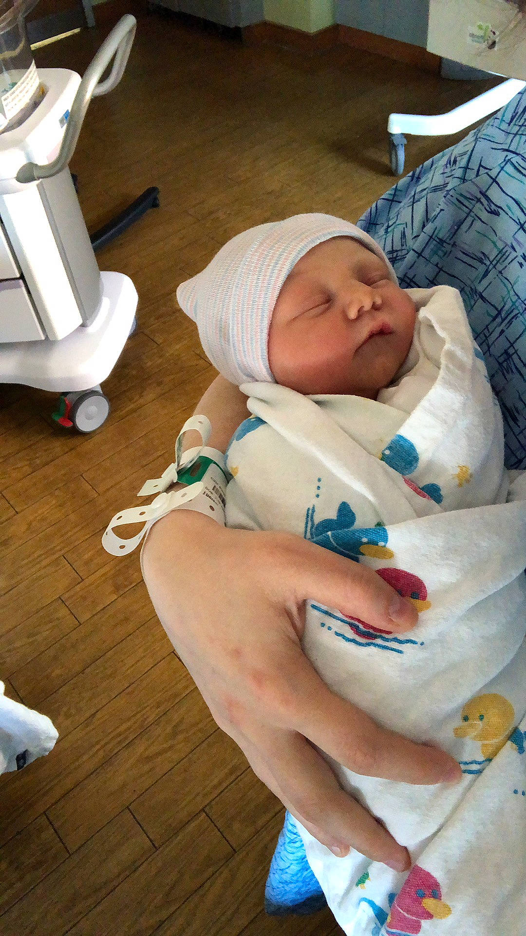 Lillian is registered to the contest to win money with this photo: baby, baby_products, baby_safety, baby_toddler_clothing, child, comfort, finger, flooring, hardwood, hat, headwear, health_care, hospital, nail, person, room, service, sitting, thumb, toddler