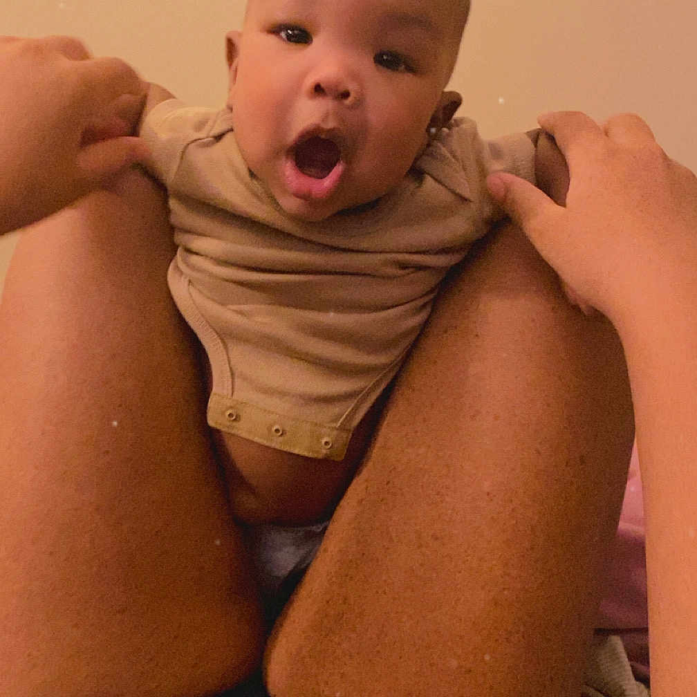 Kahlon is registered to the contest to win money with this photo: baby, body_part, casual, child, closeup, clothing, comfort, expression, face, hands, holding, human, indoor, infant, legs, light, person, skin, surprised, warm_tone