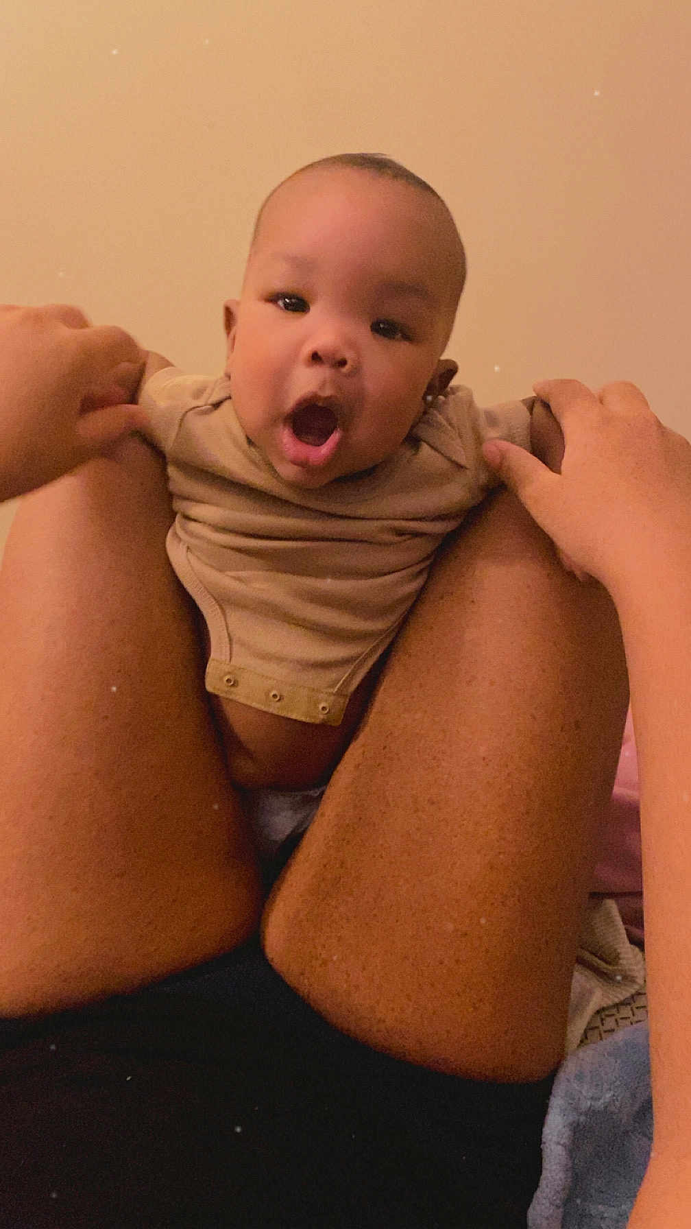 Kahlon is registered to the contest to win money with this photo: baby, body_part, casual, child, closeup, clothing, comfort, expression, face, hands, holding, human, indoor, infant, legs, light, person, skin, surprised, warm_tone