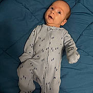 Aubriella joined the competition — help win amazing prizes! baby, infant, onesie, blue_blanket, lying_down, face, expression, curious, child, sleepwear, cozy, indoor, person, newborn, cute, patterned_clothing, head, small_hands, footed_pajamas, soft_fabric