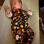 baby, infant, onesie, halloween, costume, lying_down, face, clothing, pattern, cute, padded_mat, carpet, hand, smile, indoor, person, newborn, head, sleepwear, baby_girl