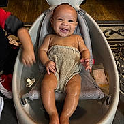 Kairo joined the competition — help win amazing prizes! baby, bathtub, child, smiling, towel, indoors, floor, rug, mesh_sling, water, happy, arm, foot, toes, person, infant, playful, wooden_floor, bath_time, seat
