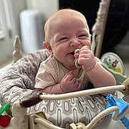 Cameron joined the competition — help win amazing prizes! baby, smiling, infant, toy, play, seat, patterned, hand, face, cheerful, indoor, child, cute, happy, closeup, soft_focus, baby_toy, grip, expression, young