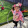 Isabella joined the competition — help win amazing prizes! child, girl, hula_hoop, pink_bows, sweatshirt, minnie_mouse, outdoor, playground, grass, fence, shadow, sunlight, pavement, toy, footwear, black_pants, curly_hair, standing, daytime, playtime