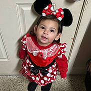 Isabella joined the competition — help win amazing prizes! toddler, child, costume, minnie_mouse, red_dress, polka_dots, bow, headband, ears, indoor, floor, door, security_camera, black_shoes, curly_hair, cute, looking_up, portrait, person, standing