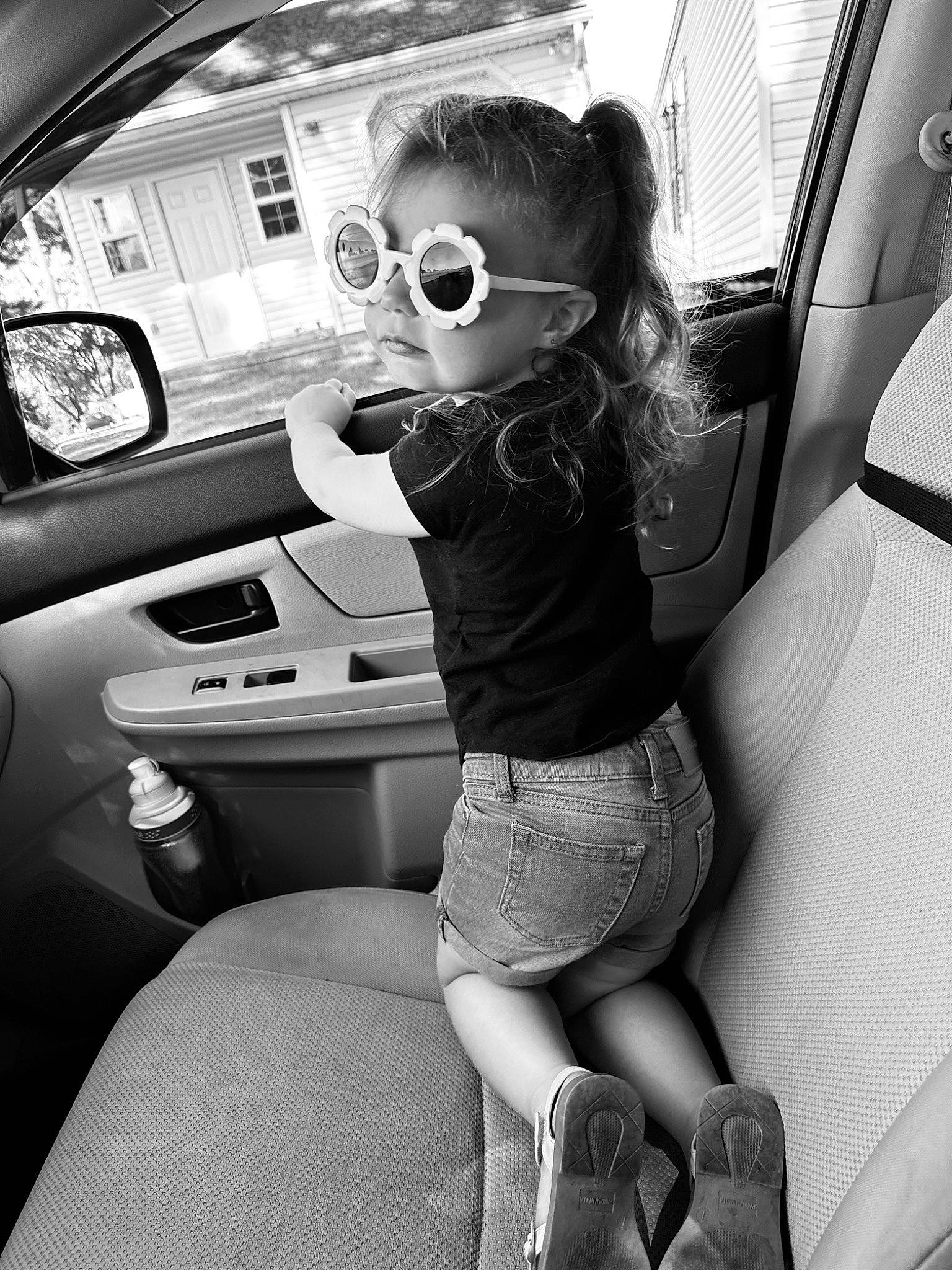 Raelyn is registered to the contest to win money with this photo: automotive_design, automotive_exterior, automotive_lighting, black, black_and_white, car, car_seat_cover, cool, eyewear, hairstyle, leg, mode_of_transport, motor_vehicle, person, shoe, steering_part, steering_wheel, style, thigh, vehicle_door