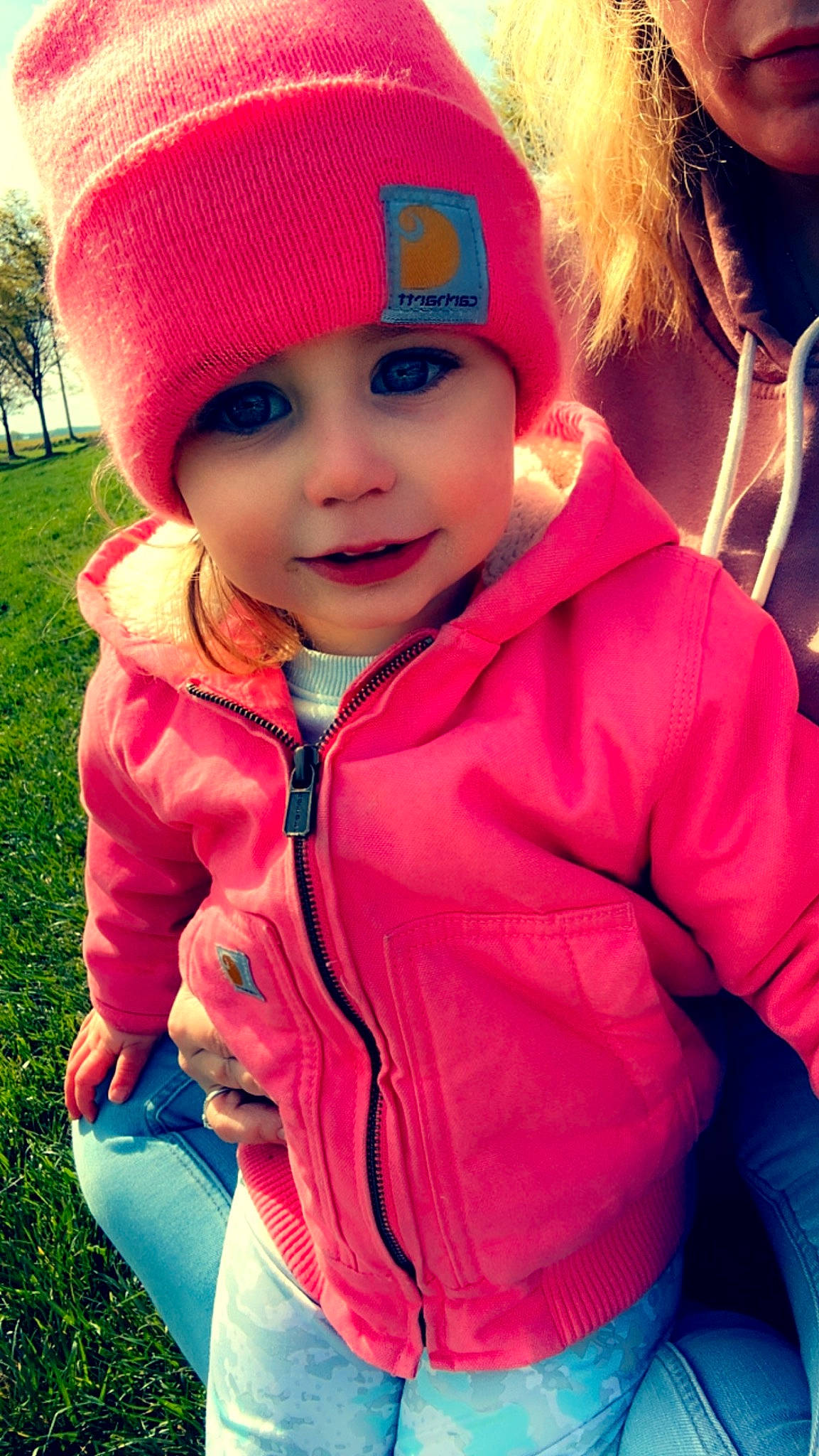 Raelyn is registered to the contest to win money with this photo: blue, cap, clothing, cool, eye, face, facial_expression, happy, head, headgear, headwear, lip, organ, outerwear, people_in_nature, person, pink, plant, red, smile