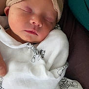 Lyra is registered to the contest to win money with this photo: baby, sleeping, blanket, headband, flower, infant, closeup, cozy, soft, cute, wrapped, peaceful, child, newborn, person, indoors, fabric, zebra_print, resting, portrait