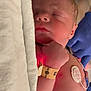 newborn, baby, sleeping, hospital, medical_equipment, blanket, face, person, video_call, woman, gloves, bed, monitoring, hospital_room, patient, closeup, skin, healthcare, indoor, rest