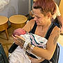 newborn, mother, hospital, wheelchair, tattoos, baby, woman, holding, blanket, indoor, medical, love, family, parent, rest, arm, person, smile, face, seated