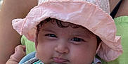 Amira Naima a rejoint le concours — aidez-le/la à gagner de superbes lots ! baby, child, infant, hat, pink_hat, striped_clothing, green_stripes, orange_logo, curly_hair, closeup, portrait, person, cute, chubby_cheeks, holding, adult, green_top, outdoor, soft_light, summer