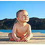 Maé a rejoint le concours — aidez-le/la à gagner de superbes lots ! baby, child, outdoor, sunlight, smile, dock, water, mountain, sky, nature, sitting, barefoot, happy, cute, summer, portrait, daytime, skin, blue_sky, peaceful