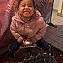 background, child, clothing, cute, dinosaur, feet, floor, fun, hands, happy, indoor, jacket, mural, person, play, portrait, ride, smiling, tile, toy