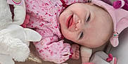 Lyana participe au concours pour gagner de l'argent avec cette photo : baby, smiling, pink_clothing, plush_toy, hat, lying_down, cute, child, soft_toys, face, happy, infant, indoors, portrait, fabric, hand, headwear, cozy, playful, closeup