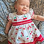 Lyana participe au concours pour gagner de l'argent avec cette photo : baby, child, smiling, dress, cherry_pattern, headband, red_bow, infant, cute, lying_down, blanket, patterned_blanket, happy, person, apparel, young_child, indoors, soft_lighting, portrait, clothing
