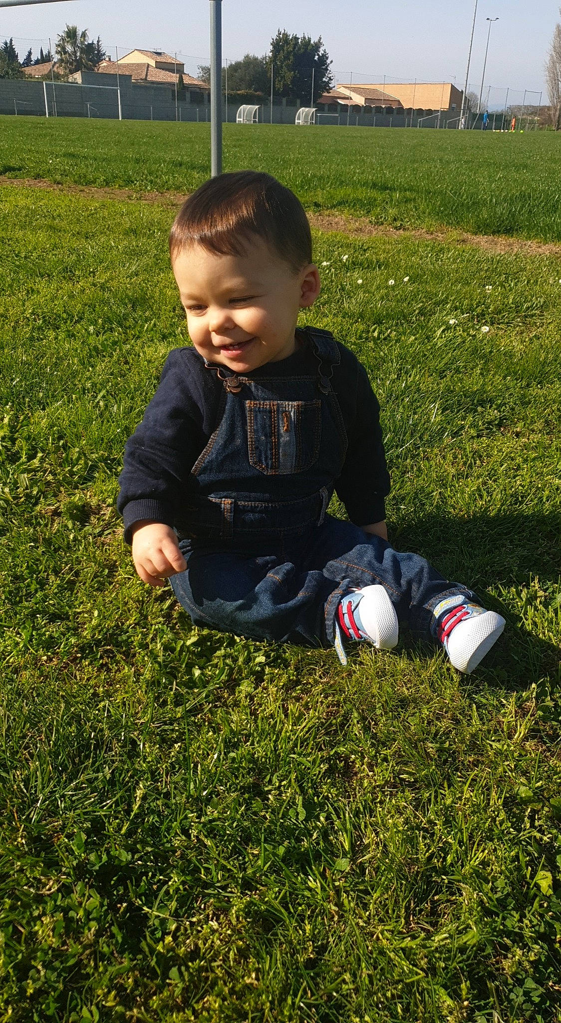 Enzo participe au concours pour gagner de l'argent avec cette photo : baby_toddler_clothing, ball, child, football, fun, grass, grass_family, grassland, groundcover, happy, joy, lawn, leaf, people_in_nature, person, plant, sitting, smile, sneakers, soccer_ball