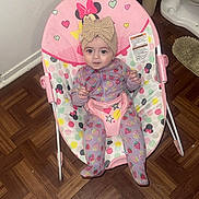Kimberly joined the competition — help win amazing prizes! baby, child, infant, baby_rocker, pink, onesie, headband, bow, strawberry_pattern, face, expression, floor, bathroom, toilet, trash_can, rug, wood_floor, seat, polka_dots, mickey_mouse