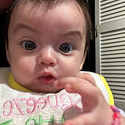 Kimberly joined the competition — help win amazing prizes! baby, infant, child, face, hand, bow, bib, adult, kiss, expression, curious, indoor, closet, door, clothing, colorful, bracelet, person, portrait, closeup