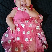 Susana joined the competition — help win amazing prizes! baby, child, pink_dress, headband, smiling, happy, lying_down, white_socks, floral_pattern, cute, infant, portrait, indoor, soft_lighting, close_up, tulle_skirt, cheerful, small_hands, dark_background, joyful