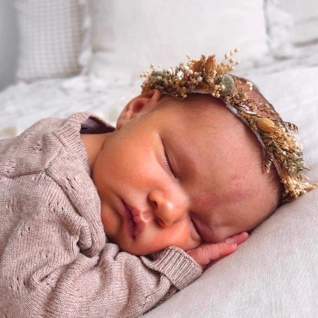 Maé participe au concours pour gagner de l'argent avec cette photo : baby, newborn, sleeping, face, head, knitted_sweater, flower_crown, pillow, soft_texture, cozy, resting, peaceful, infant, closeup, portrait, cute, toddler, homedecor, blanket, skin