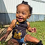 toddler, child, smiling, outdoor, grass, flower_print, denim_shorts, black_shoes, curly_hair, bow, sunlight, happy, skin, person, sitting, nature, daylight, casual_clothing, portrait, baby