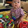 Amber joined the competition — help win amazing prizes! animal, baby, blanket, child, colorful, curious, dog, face, floor, furniture, hand, indoor, infant, playtime, portrait, purple_clothing, rainbow_design, sitting, toys, wooden_floor