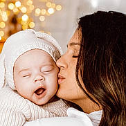 Charlotte participe au concours pour gagner de l'argent avec cette photo : baby, woman, kiss, yawning, knitted_hat, cozy_clothing, closeup, portrait, warm_lighting, bokeh, indoor, love, affection, tenderness, family, mother, child, cute, sleepy, intimate