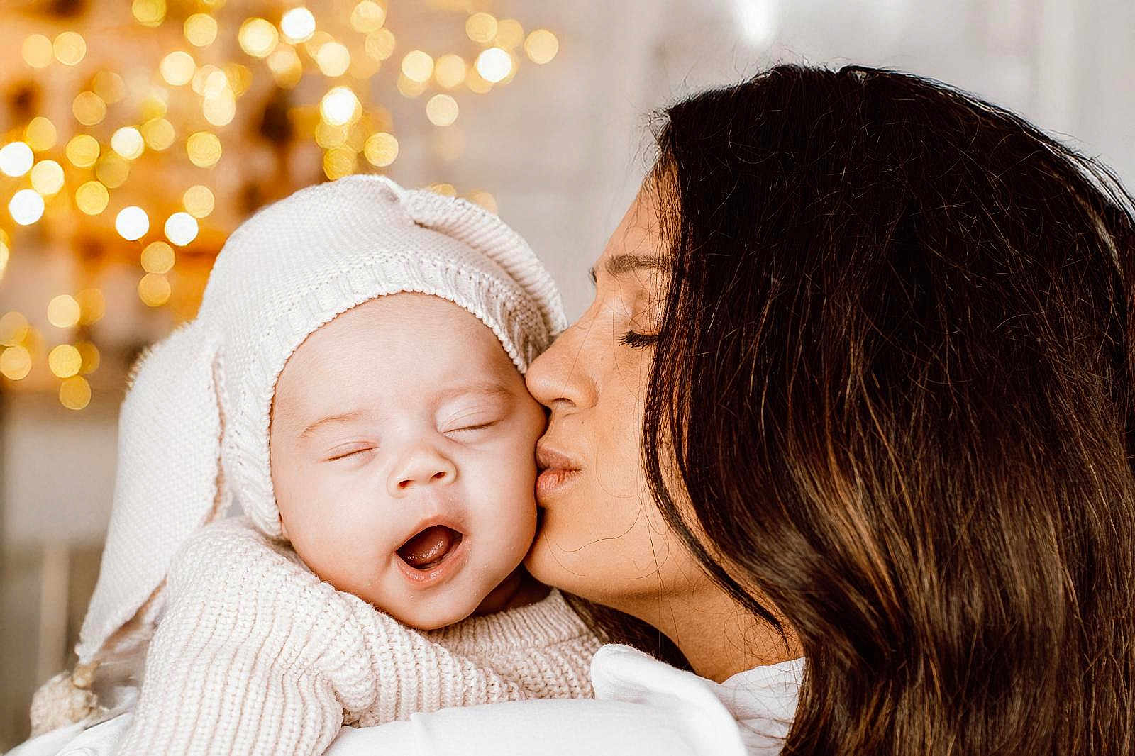 Charlotte participe au concours pour gagner de l'argent avec cette photo : baby, woman, kiss, yawning, knitted_hat, cozy_clothing, closeup, portrait, warm_lighting, bokeh, indoor, love, affection, tenderness, family, mother, child, cute, sleepy, intimate