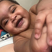 Kash is registered to the contest to win money with this photo: baby, smiling, happy, closeup, face, hand, arm, skin, child, infant, cute, portrait, expression, person, young, indoor, candid, joy, reaching, touch