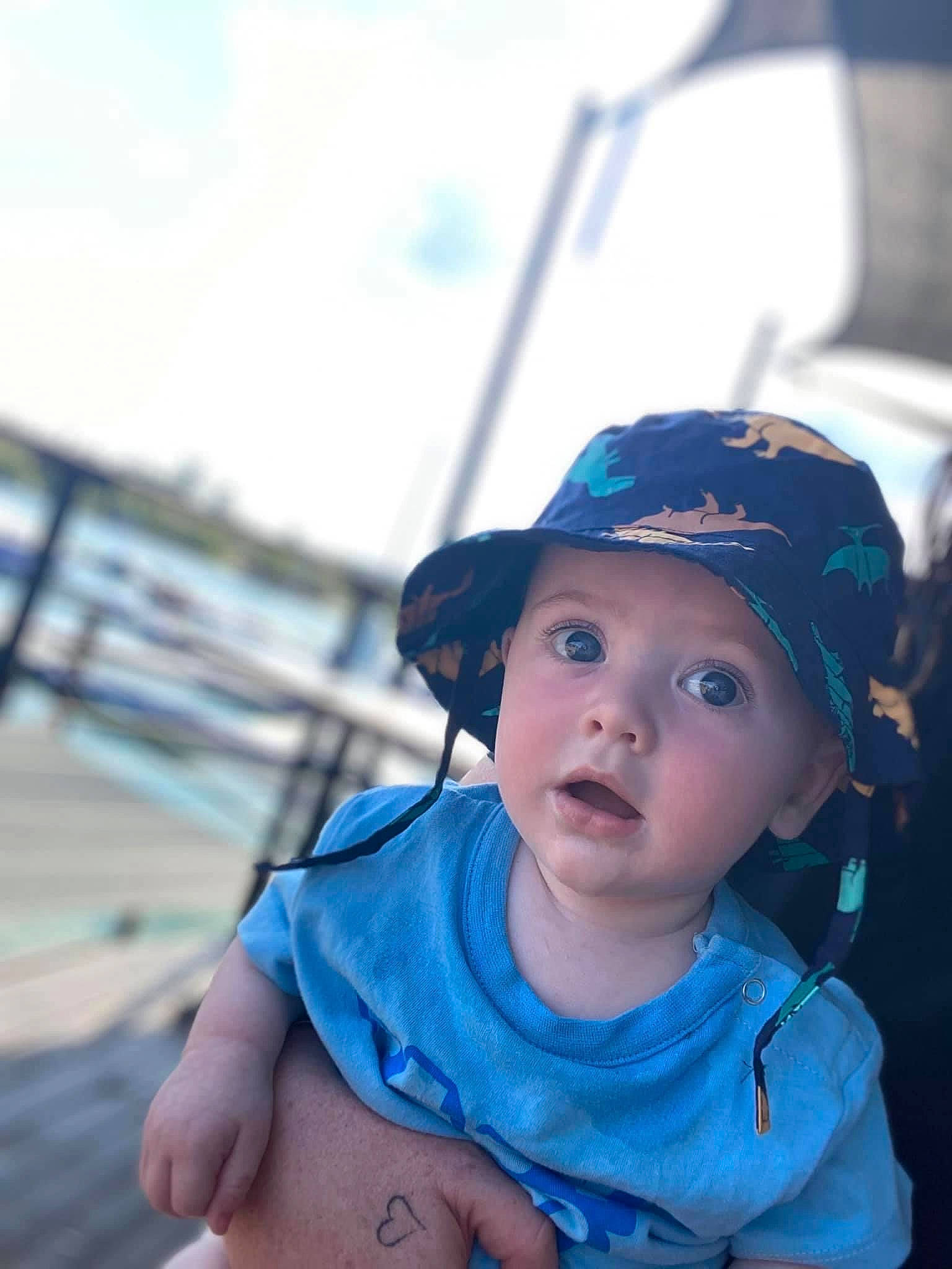 Khylan is registered to the contest to win money with this photo: azure, baby, baby_toddler_clothing, baseball_cap, cap, child, cool, electric_blue, fashion_accessory, flash_photography, fun, happy, headgear, headwear, leisure, ocean, person, recreation, sky, surprise
