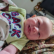 Owen joined the competition — help win amazing prizes! baby, smile, infant, quilt, blanket, clothing, face, person, indoor, television, toy, furniture, happy, child, head, sitting, colorful, fabric, home, cute