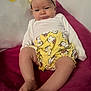 baby, infant, headband, yellow, hello_kitty, clothing, shorts, blanket, pink, person, face, legs, feet, cute, expression, indoors, sitting, child, apparel, soft_fabric