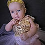 Annabella is registered to the contest to win money with this photo: baby, child, crown, gold, dress, sparkle, pink, tutu, portrait, cute, infant, person, face, seated, clothing, young, adorable, indoor, expression, headwear