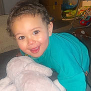 Yohannes is registered to the contest to win money with this photo: blanket, box, carpet, child, clothing, crawling, curtain, face, floor, furniture, happy, home, indoor, person, playtime, smiling, soft_toy, stuffed_animal, toddler, toy