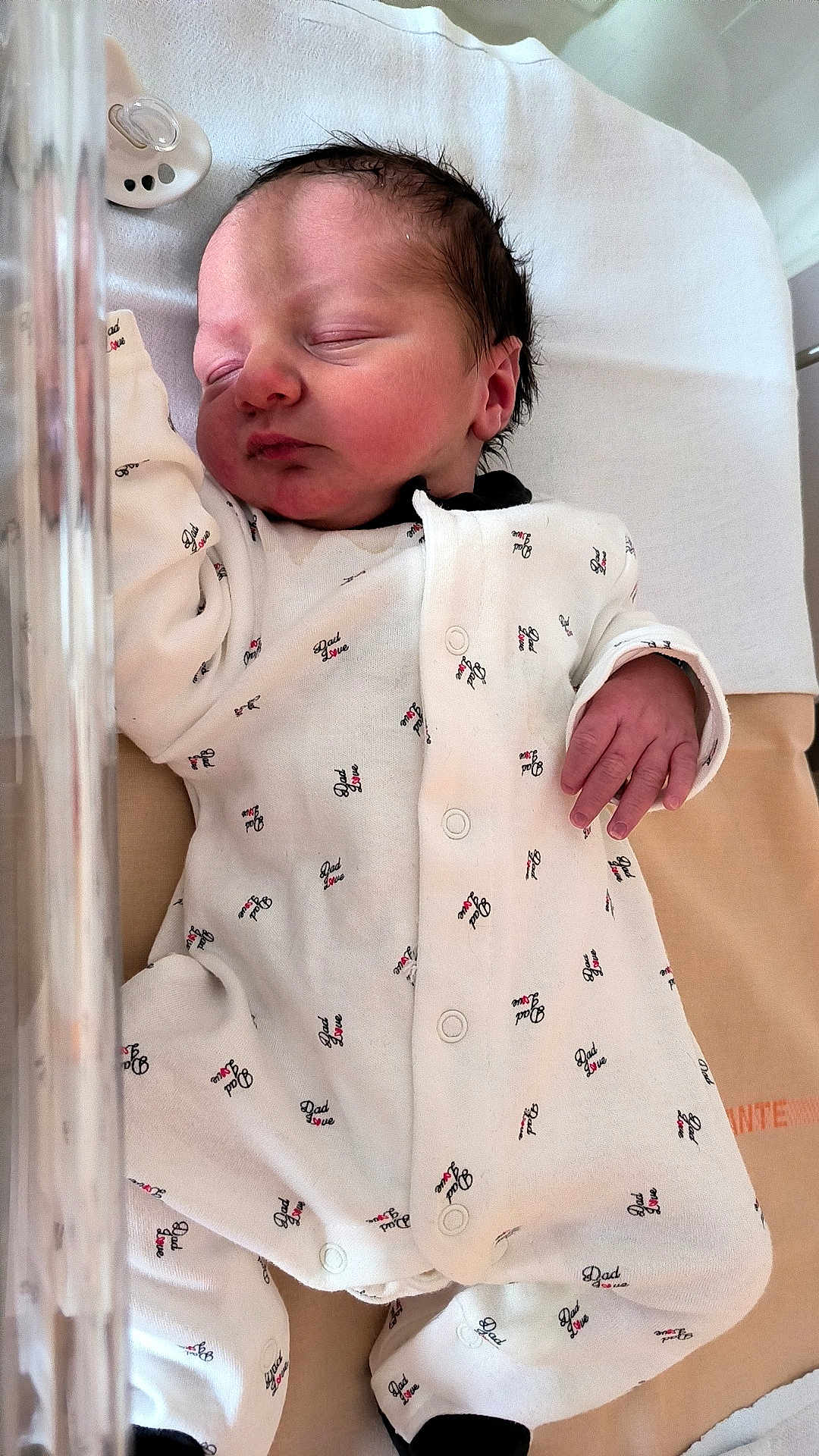 Ethan a rejoint le concours — aidez-le/la à gagner de superbes lots ! newborn, baby, sleeping, infant, onesie, clothing, hospital, pacifier, bed, resting, cute, peaceful, soft, skin, hand, face, person, child, young, sleep