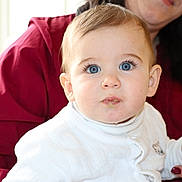 Milo participe au concours pour gagner de l'argent avec cette photo : adult, baby, blue_eyes, child, closeup, curious, cute, eyelashes, face, hand, holding, human, indoor, infant, long_sleeves, mouth, person, portrait, skin, white_clothing