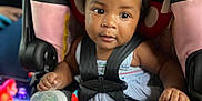 Charm Ross joined the competition — help win amazing prizes! baby, child, car_seat, toy, bottle, headband, minnie_mouse_ears, yellow_bow, sitting, curious, black_hair, blue_outfit, sock, infant, seat_belt, indoors, cute, face, portrait, closeup