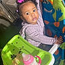 toddler, child, high_chair, pink_bow, curly_hair, sippy_cup, snacks, indoor, furniture, face, eyes, clothing, tray, holding, hair_accessory, colorful, baby_food, room, sink, basket