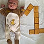 baby, infant, onesie, simba, blanket, biscuit, number_one, food_art, cute, lying_down, celebration, snack, child, portrait, baby_clothing, toddler, light, indoor, soft_texture, playful