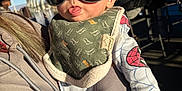 Makaio joined the competition — help win amazing prizes! baby, sunglasses, bib, person, indoor, hoodie, hand, face, tongue, child, dinosaur_pattern, spiderman_pattern, light, shadow, cafe, chair, window, adult, clothing, holding