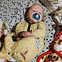 baby, pacifier, yellow_onesie, blanket, bedspread, polka_dot, infant, lying_down, cozy, soft_fabric, cute, child, indoors, sleepwear, comfort, motion_blur, face, head, baby_girl_or_boy, resting