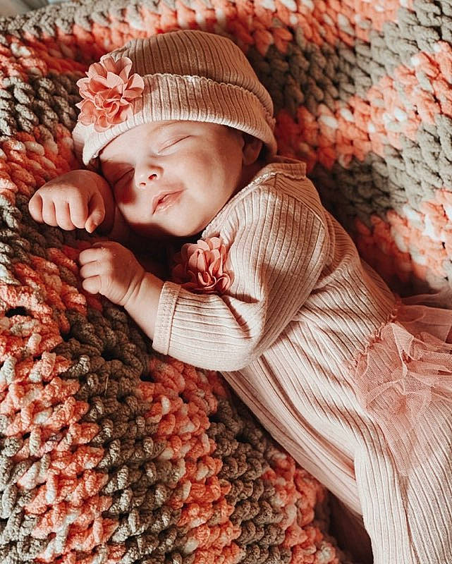 Isla is registered to the contest to win money with this photo: baby, cap, comfort, crochet, design, fashion_accessory, happy, headwear, knit_cap, linens, natural_foods, orange, pattern, peach, people_in_nature, person, smile, textile, toddler, wood