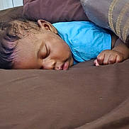 Judah is registered to the contest to win money with this photo: baby, sleeping, blue_shirt, blanket, brown, cozy, peaceful, infant, child, face, hand, indoors, rest, nap, cute, calm, soft, young, portrait, skin