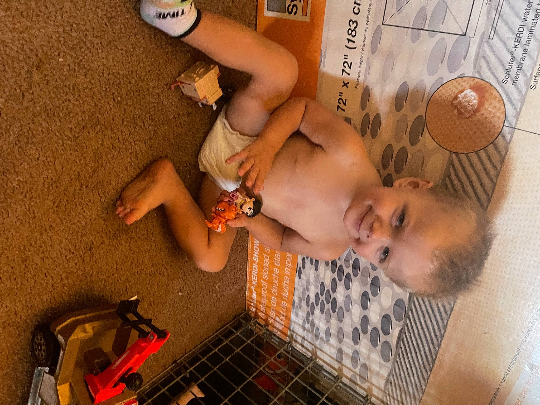 Ayden is registered to the contest to win money with this photo: abdomen, arm, baby, barechested, chest, child, elbow, flooring, fun, hand, human_leg, joy, orange, person, plumbing_fixture, room, snapshot, thigh, toddler, toy