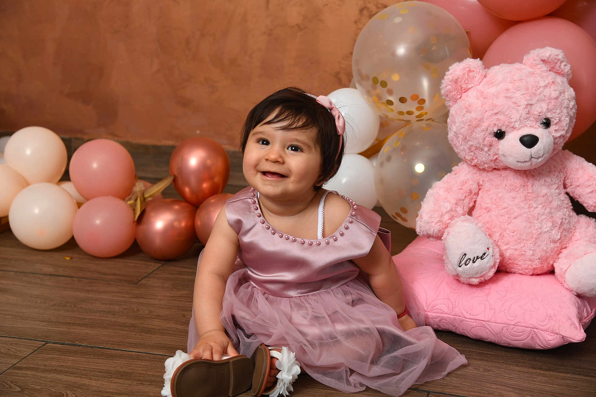 Adriana a rejoint le concours — aidez-le/la à gagner de superbes lots ! toddler, child, pink_dress, balloons, teddy_bear, toy, smile, happy, floor, wooden_floor, headband, dress, pink, cute, portrait, sitting, indoor, celebration, baby, playful
