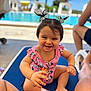 toddler, child, swimsuit, pink, pigtails, bows, pool, outdoor, sunny, smiling, happy, person, legs, blue, lounge_chair, water, palm_trees, summer, vacation, toy