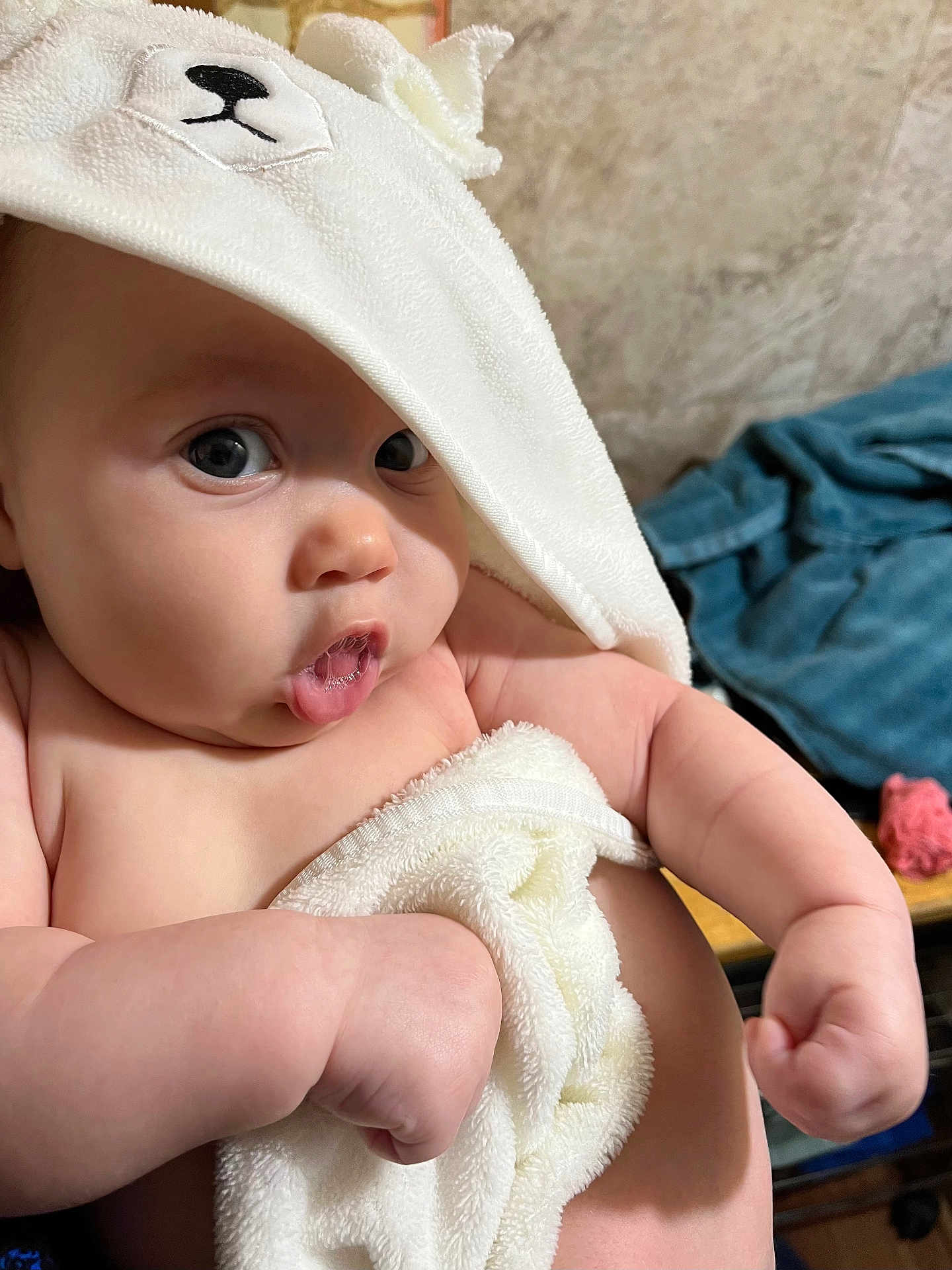 Laila is registered to the contest to win money with this photo: baby, towel, face, expression, skin, arm, hand, hood, cute, indoor, person, child, white, plush, soft, portrait, newborn, infant, closeup, funny_face
