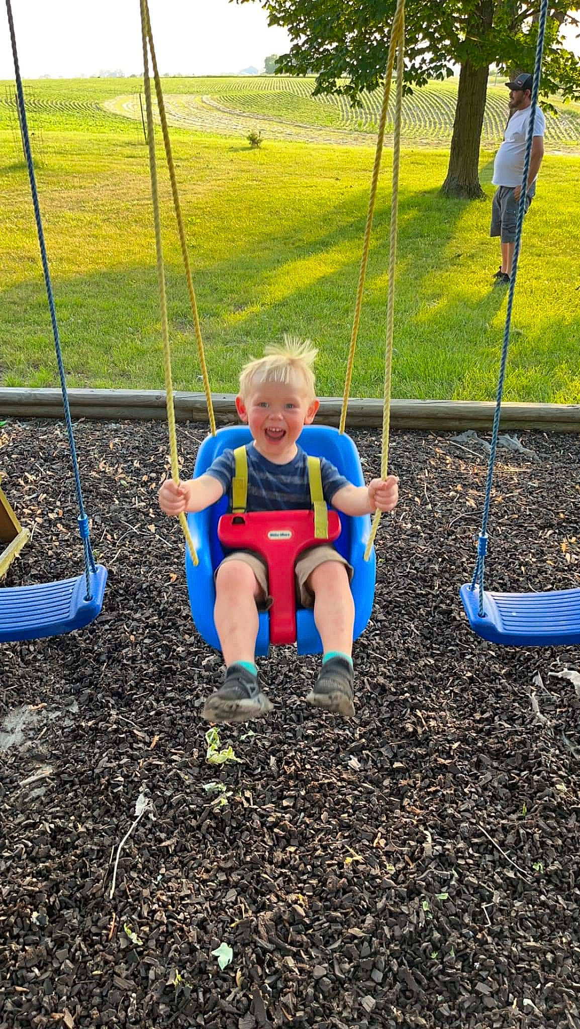 Nash is registered to the contest to win money with this photo: baby, child, city, electric_blue, fun, grass, headwear, leisure, outdoor_play_equipment, outdoor_recreation, people_in_nature, person, plant, play, playground, recreation, shorts, soil, sports, swing
