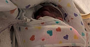 Alma joined the competition — help win amazing prizes! newborn, baby, blanket, hospital, medical_tubes, face, infant, swaddled, heart_pattern, sleeping, fragile, bed, soft_lighting, closeup, person, healthcare, pediatric, resting, premature, nursery